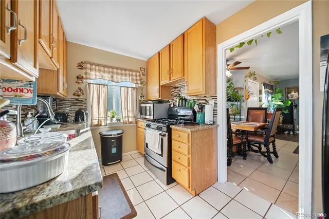 a kitchen with stainless steel appliances kitchen island granite countertop a stove a sink and a refrigerator