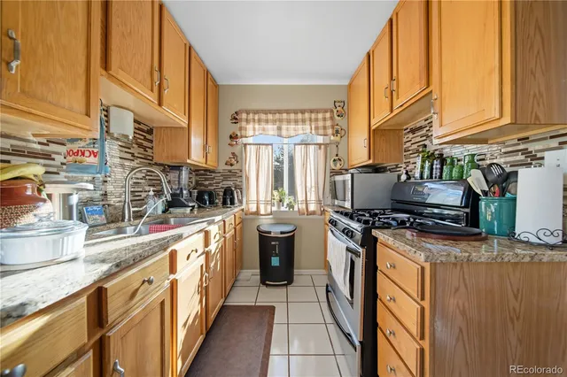 a kitchen with stainless steel appliances granite countertop a stove a sink and a microwave