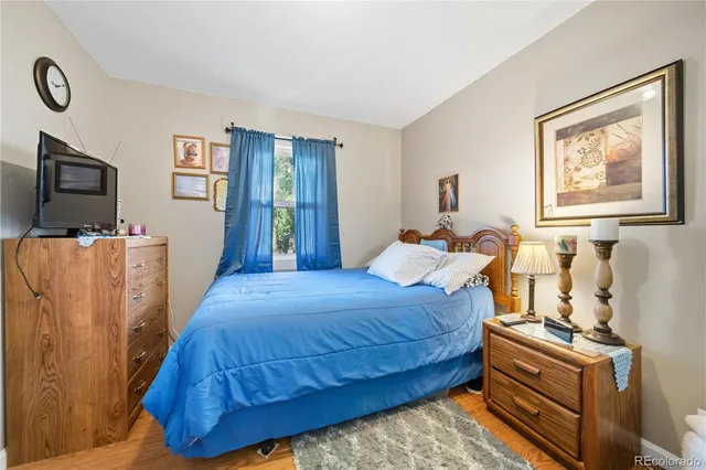 a bedroom with a bed and a tv on the dresser