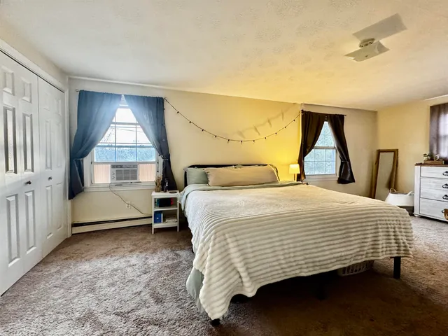 a bedroom with a bed a dresser and window