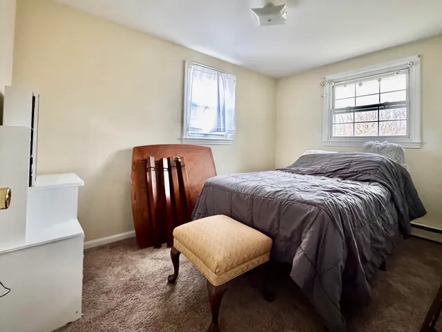 a bed room with a bed and two windows