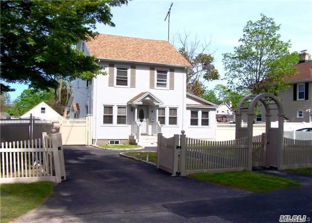 21 Rhodes Avenue Bay Shore, NY 11706 - Photo 1 of 6 a front view of a house with a garden