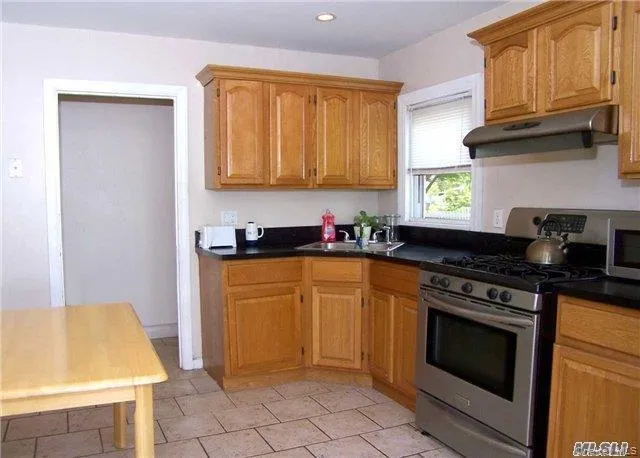a kitchen with a stove a sink and a cabinets