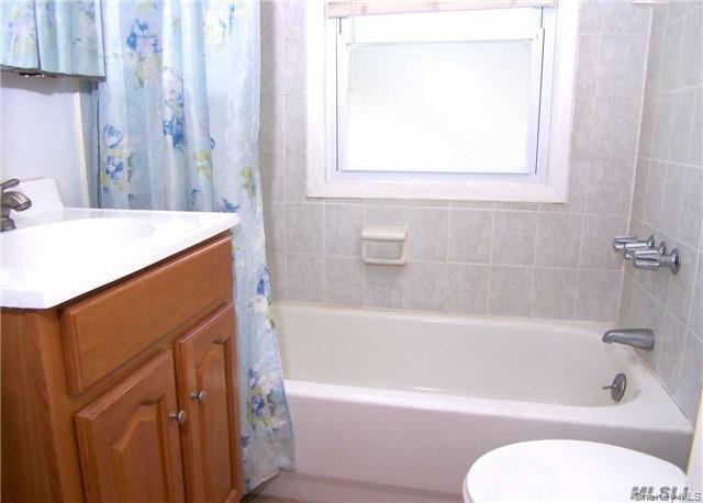 21 Rhodes Avenue Bay Shore, NY 11706 - Photo 6 of 6 a bathroom with a sink a toilet and bathtub