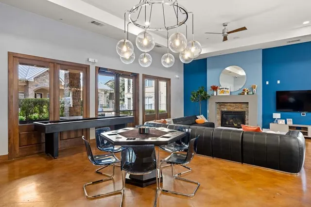 a living room with furniture a fireplace and large windows