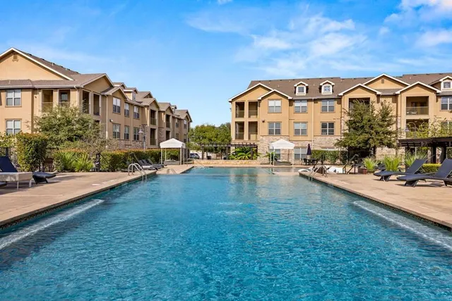 a view of multiple houses with a big yard and potted plants