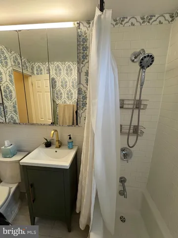 a bathroom with a sink and mirror with toilet
