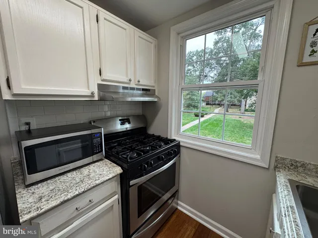a kitchen with appliances cabinets and a window