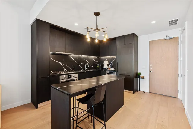 a kitchen with stainless steel appliances kitchen island a chandelier