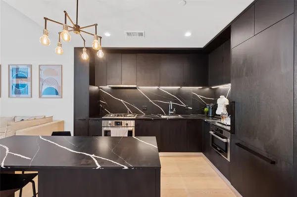 a kitchen with kitchen island a stove and a refrigerator