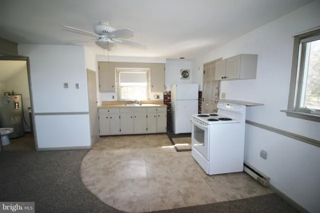 a kitchen with granite countertop a sink stove and refrigerator