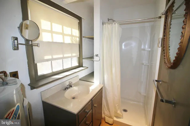 a bathroom with a shower a sink and a mirror
