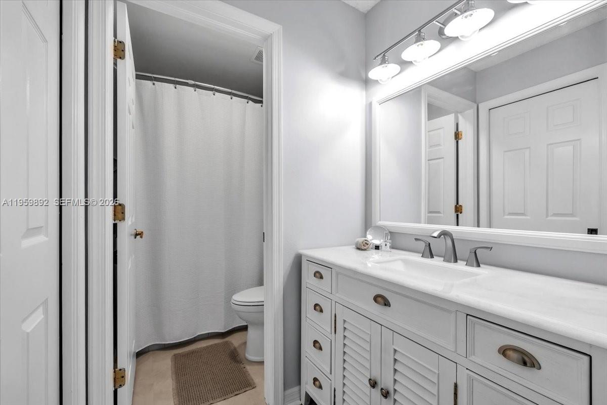 280 Timber Lake Circle, Unit 201 Naples, FL 34104 - Photo 14 of 34 a bathroom with a sink a toilet and a mirror