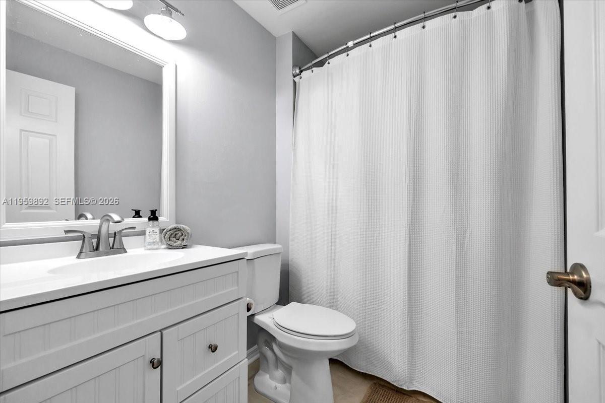 280 Timber Lake Circle, Unit 201 Naples, FL 34104 - Photo 17 of 34 a bathroom with a sink a toilet and a mirror