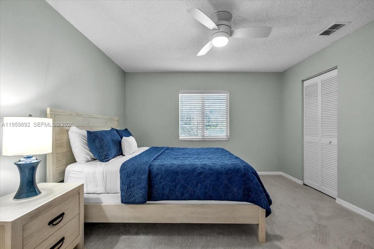 280 Timber Lake Circle, Unit 201 Naples, FL 34104 - Photo 18 of 34 a bedroom with a bed and a chandelier