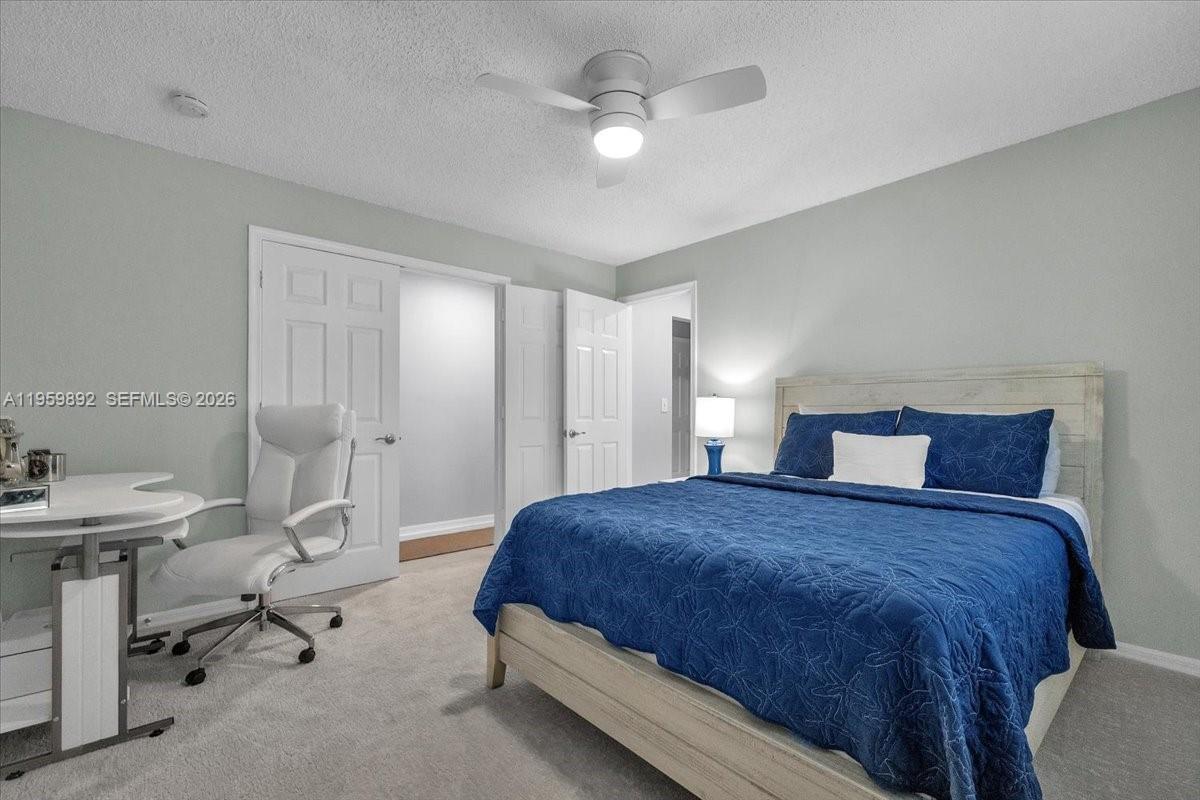 280 Timber Lake Circle, Unit 201 Naples, FL 34104 - Photo 19 of 34 a spacious bedroom with a bed and a table in it