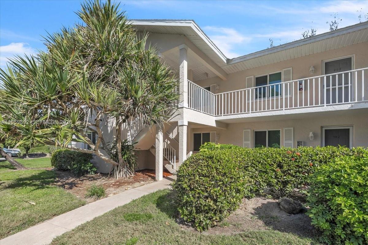 280 Timber Lake Circle, Unit 201 Naples, FL 34104 - Photo 26 of 34 a front view of a house with garden