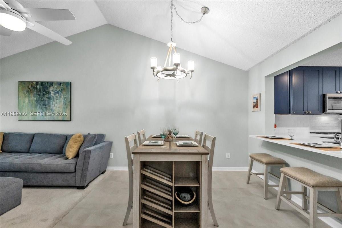280 Timber Lake Circle, Unit 201 Naples, FL 34104 - Photo 5 of 34 a living room with furniture and a chandelier
