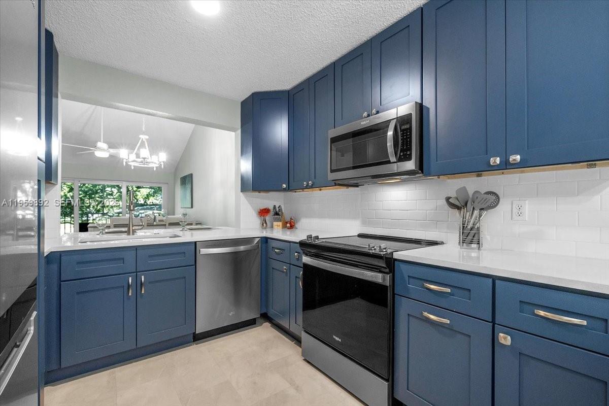 280 Timber Lake Circle, Unit 201 Naples, FL 34104 - Photo 8 of 34 a kitchen with granite countertop wooden cabinets and stainless steel appliances