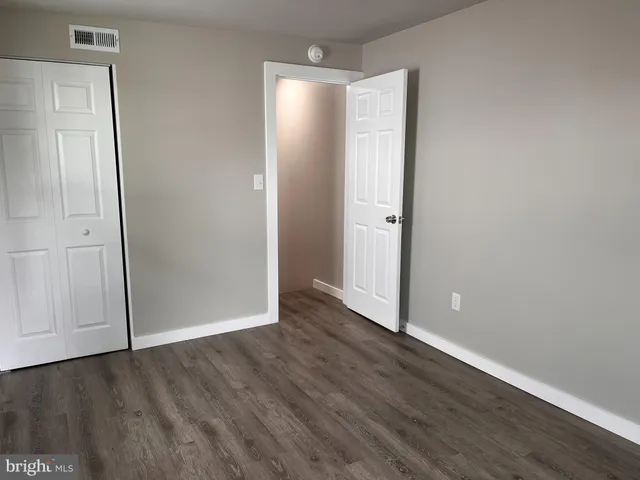 an empty room with wooden floor and mirror
