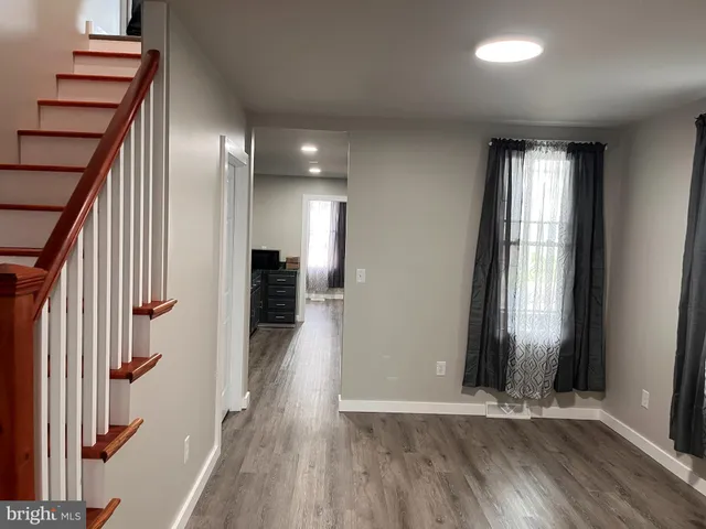 a view of a hallway with wooden floor and staircase