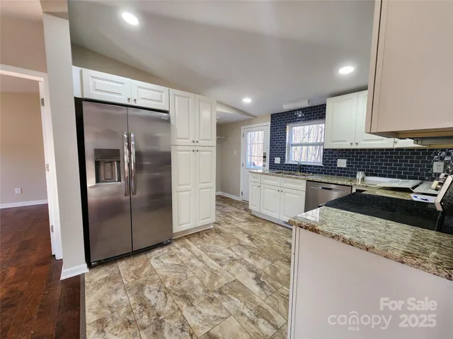 a kitchen with granite countertop a refrigerator and a sink
