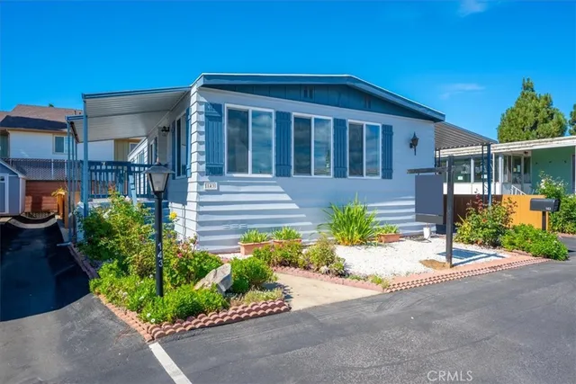 a front view of a house with a yard and potted plants