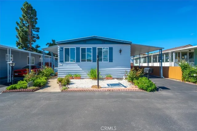 a front view of a house with a yard and potted plants