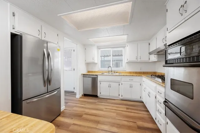 a kitchen with granite countertop a refrigerator stove and sink