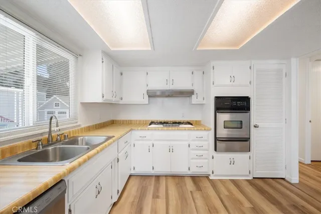 a kitchen with granite countertop a sink and cabinets with wooden floors