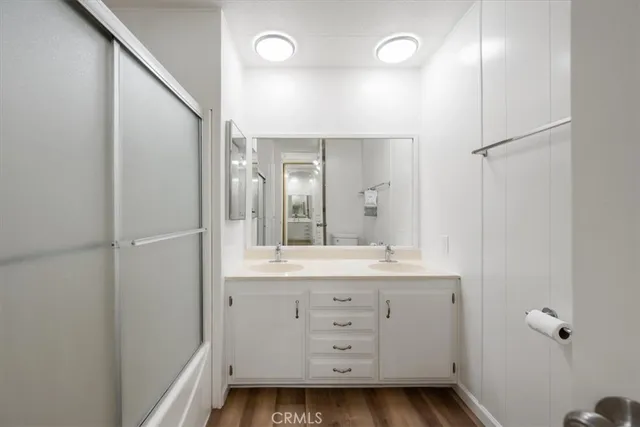 a bathroom with a double vanity sink a mirror and shower