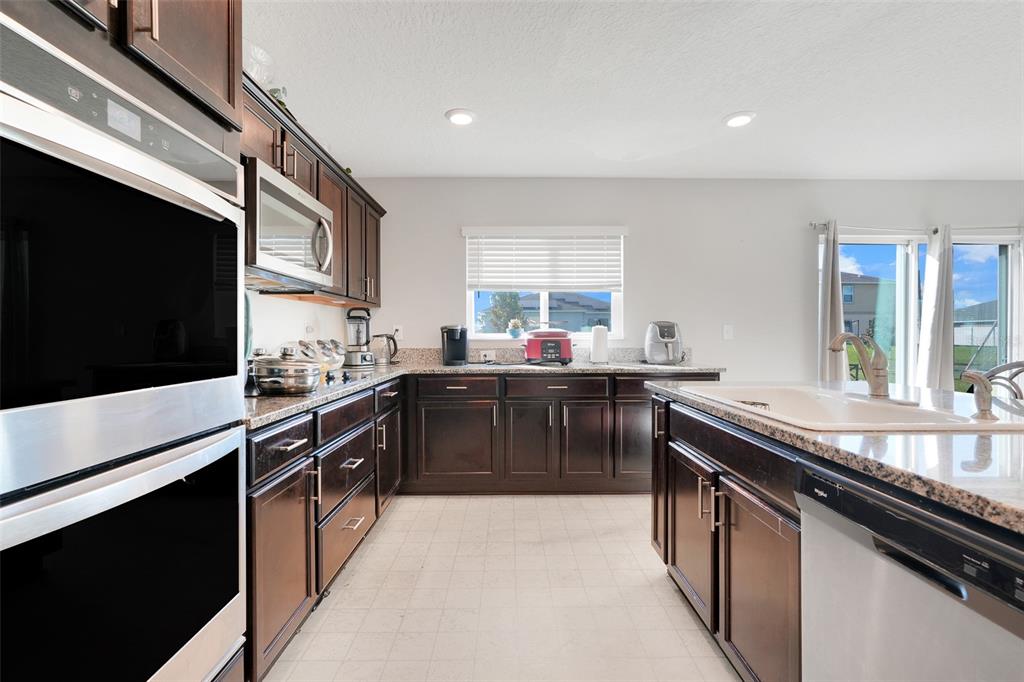 2111 Ficus Street Mascotte, FL 34753 - Photo 12 of 24 a kitchen with stainless steel appliances granite countertop a sink stove and cabinets