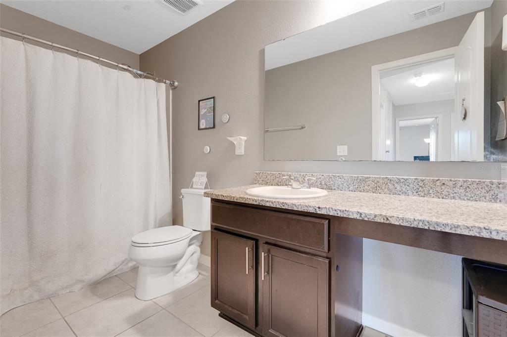 2111 Ficus Street Mascotte, FL 34753 - Photo 16 of 24 a bathroom with a granite countertop sink a toilet and a mirror