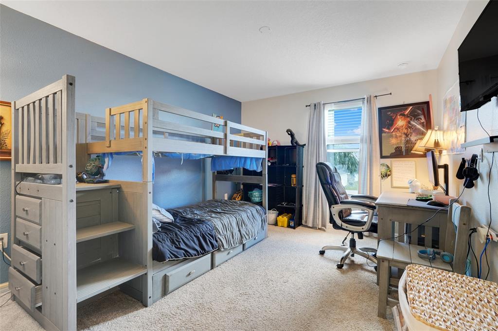 2111 Ficus Street Mascotte, FL 34753 - Photo 17 of 24 a bedroom with furniture and a flat screen tv