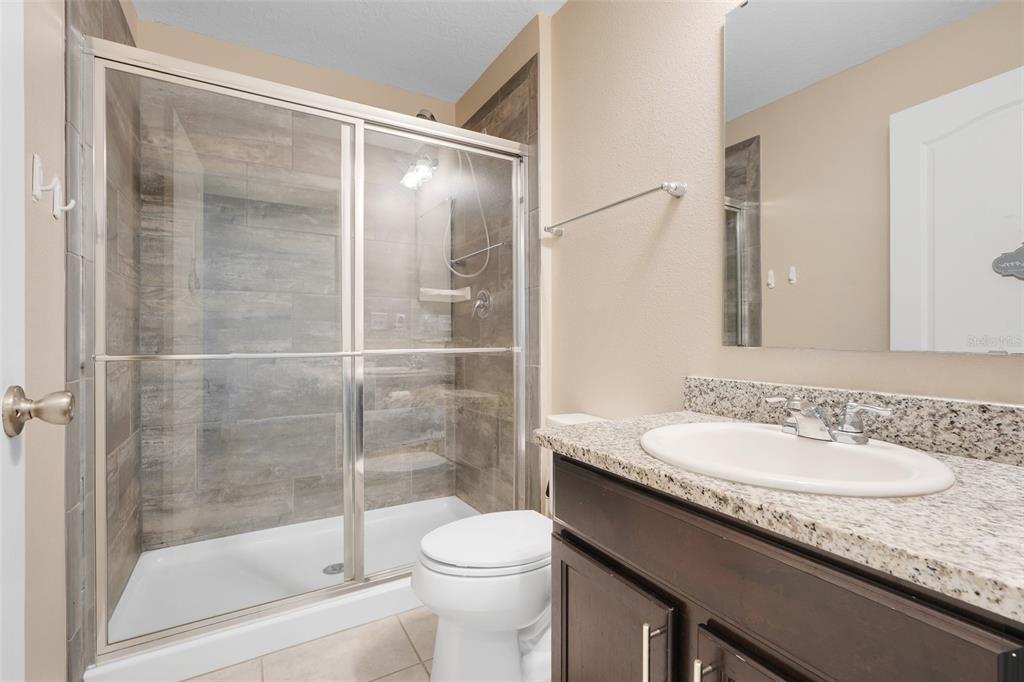 2111 Ficus Street Mascotte, FL 34753 - Photo 5 of 24 a bathroom with a granite countertop sink a toilet and shower