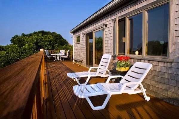 a view of a patio with table and chairs with wooden floor and fence