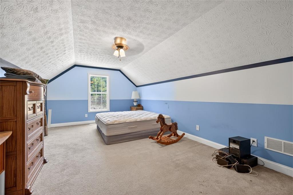 89 Katie Spring Lane Jefferson, GA 30549 - Photo 40 of 63 a bedroom with a bed and a chandelier