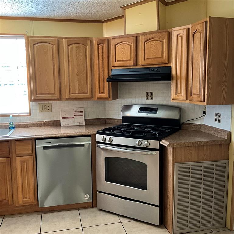 116 Traders Cove Boulevard DeBary, FL 32713 - Photo 26 of 60 a kitchen with stainless steel appliances granite countertop a stove and a microwave