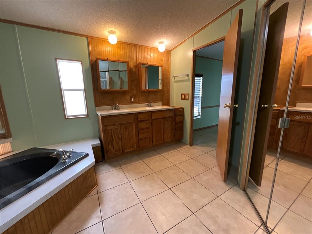 116 Traders Cove Boulevard DeBary, FL 32713 - Photo 47 of 60 a large bathroom with a large mirror vanity and bathtub