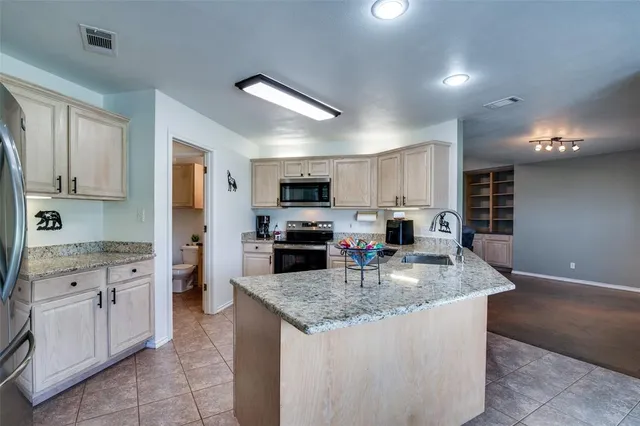a kitchen with kitchen island granite countertop a stove sink and microwave