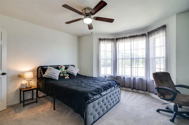 a bedroom with a bed chair and a large window