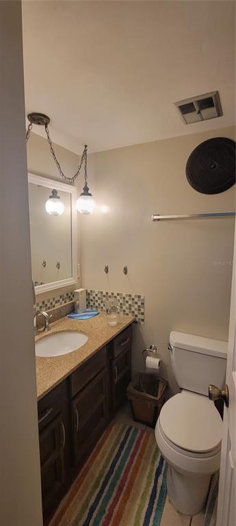 1120 Southwest 19th Place Gainesville, FL 32601 - Photo 18 of 30 a bathroom with a granite countertop toilet sink and mirror