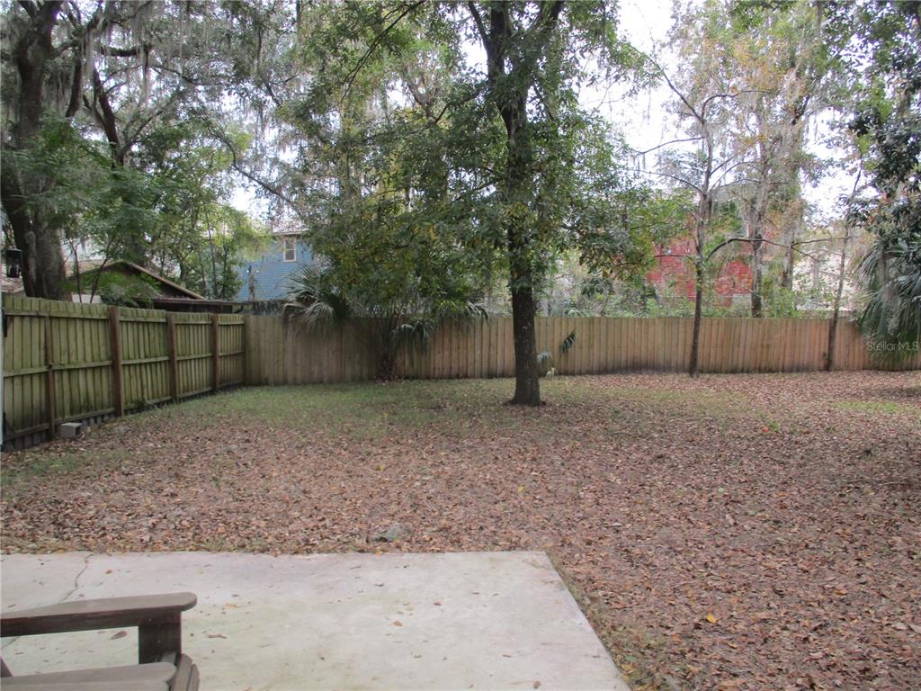1120 Southwest 19th Place Gainesville, FL 32601 - Photo 25 of 30 a backyard of a house with lots of tall trees