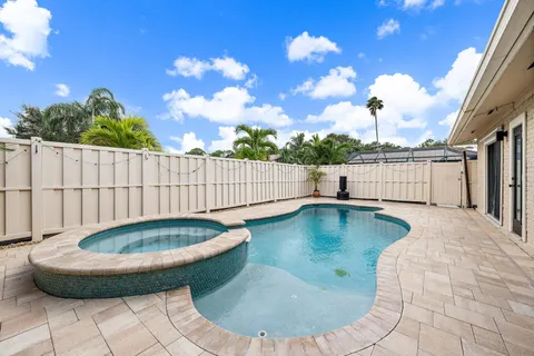 a view of a swimming pool with a yard from a balcony