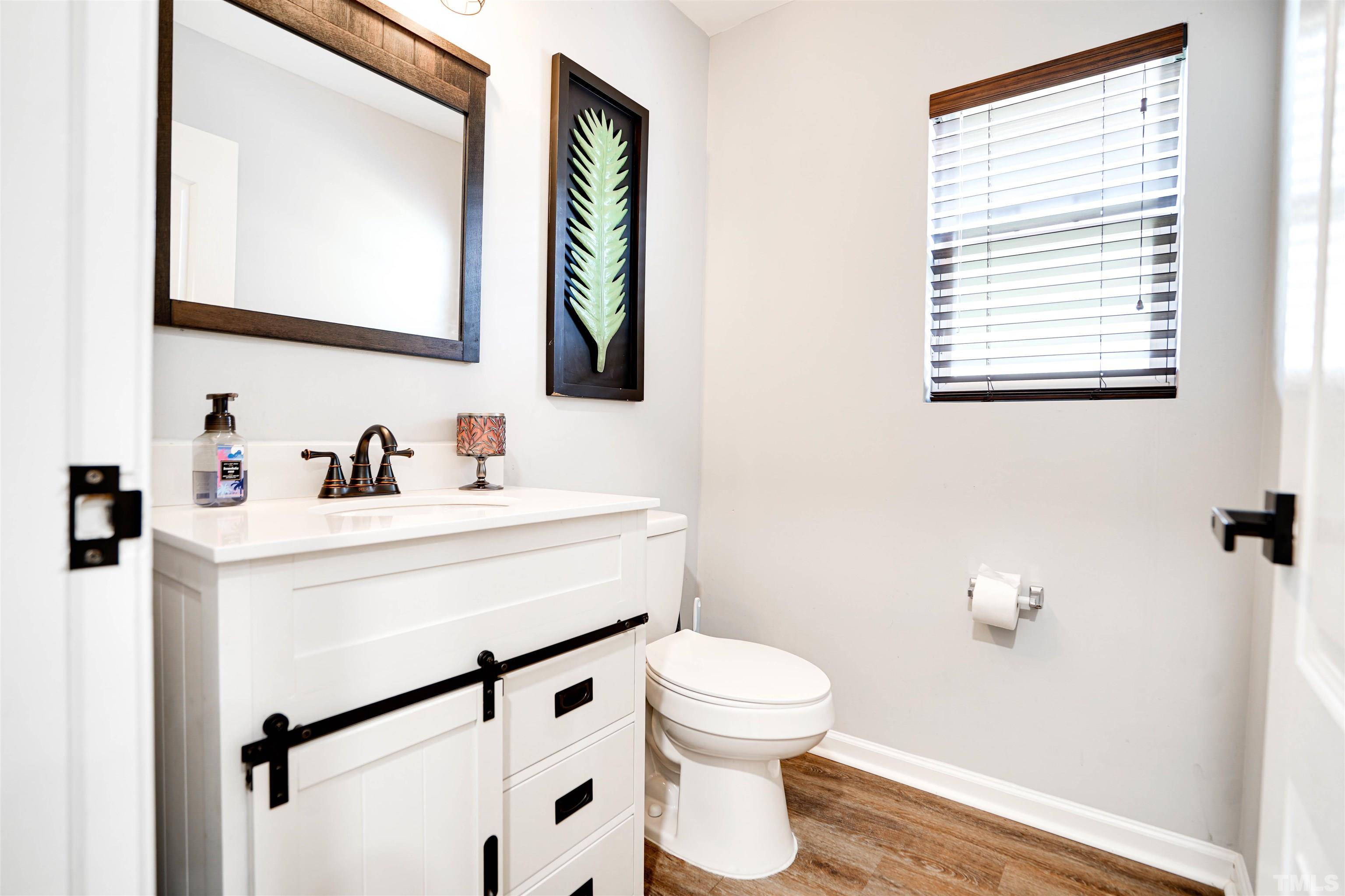 3626 Willano Way Raleigh, NC 27610 - Photo 11 of 20 a bathroom with a sink a mirror and a toilet