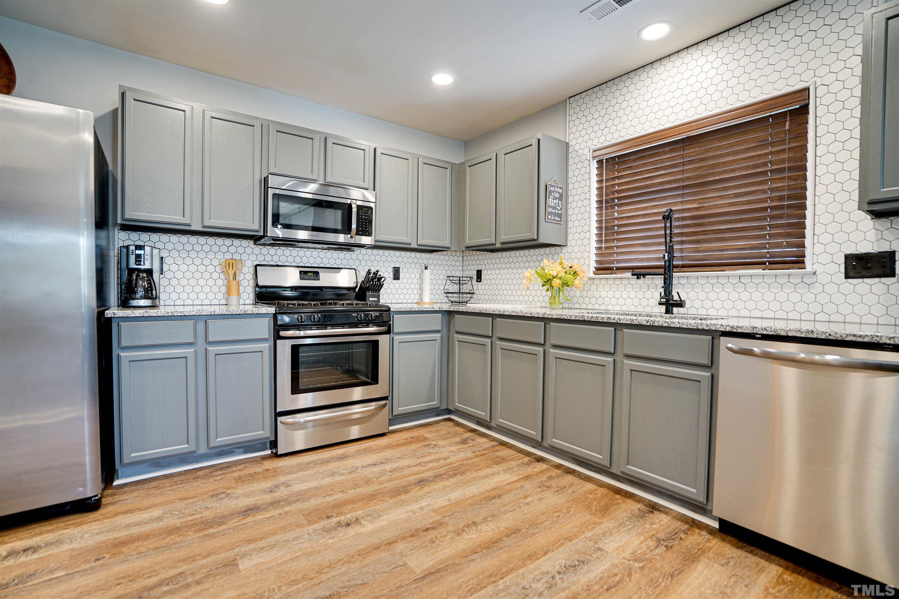 3626 Willano Way Raleigh, NC 27610 - Photo 7 of 20 a kitchen with stainless steel appliances granite countertop a stove a sink and a refrigerator