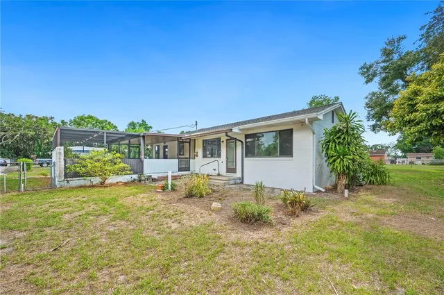 a front view of house with yard and trees in the background