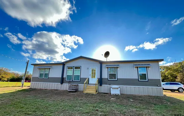 a view of a house with backyard and sitting area