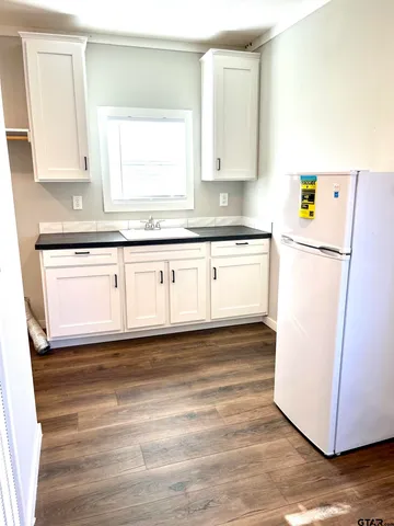 a view of a refrigerator in kitchen and wooden floor