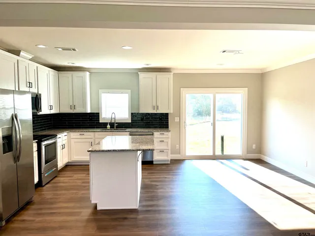 a kitchen with a refrigerator and white cabinets